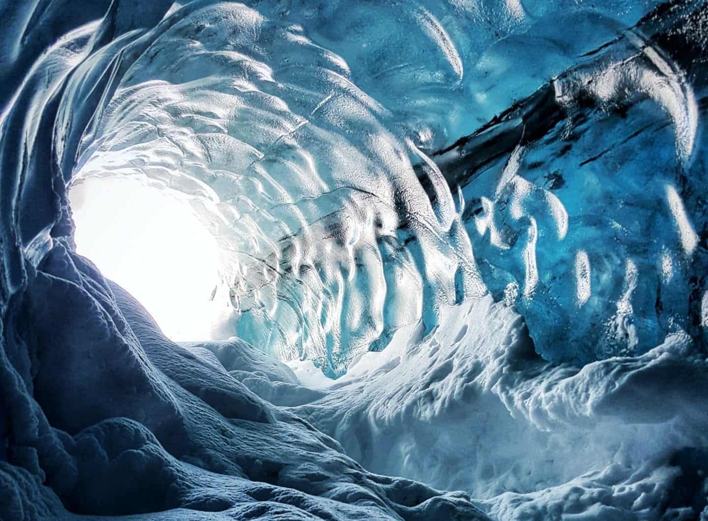 experiencias únicas en Vik Islandia, túnel hecho de hielo que pasa a través de cuevas de hielo subterráneas hacia la luz brillante del exterior