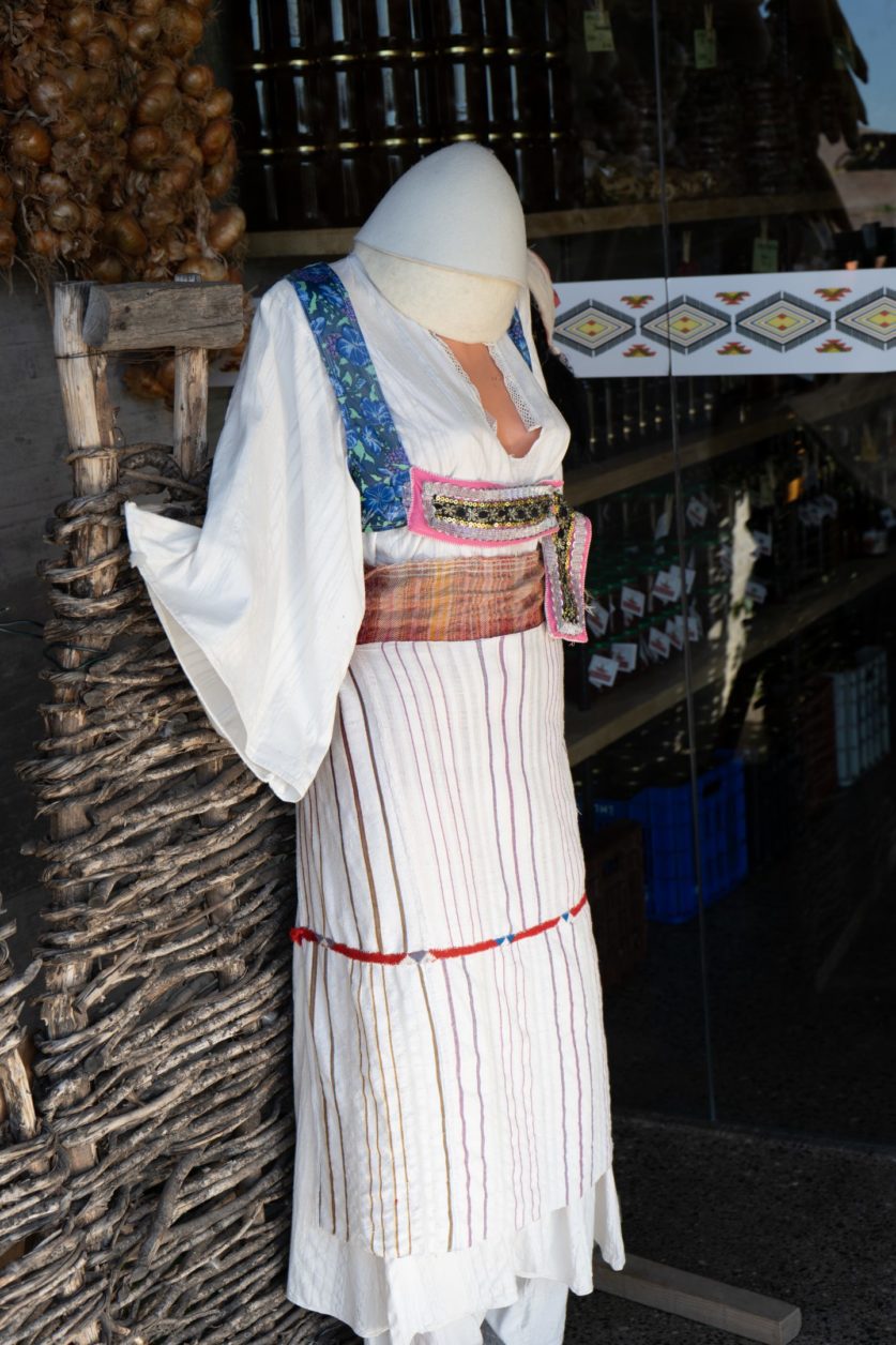 Qué visitar en Korca Albania, maniquí sin cabeza que muestra el vestido tradicional albanés en la calle fuera de la tienda
