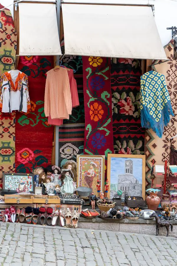 Impresionantes recuerdos albaneses, vista de una tienda de recuerdos albaneses desde la calle, con ropa, tapices, zapatos, muñecas y fotografías en marcos