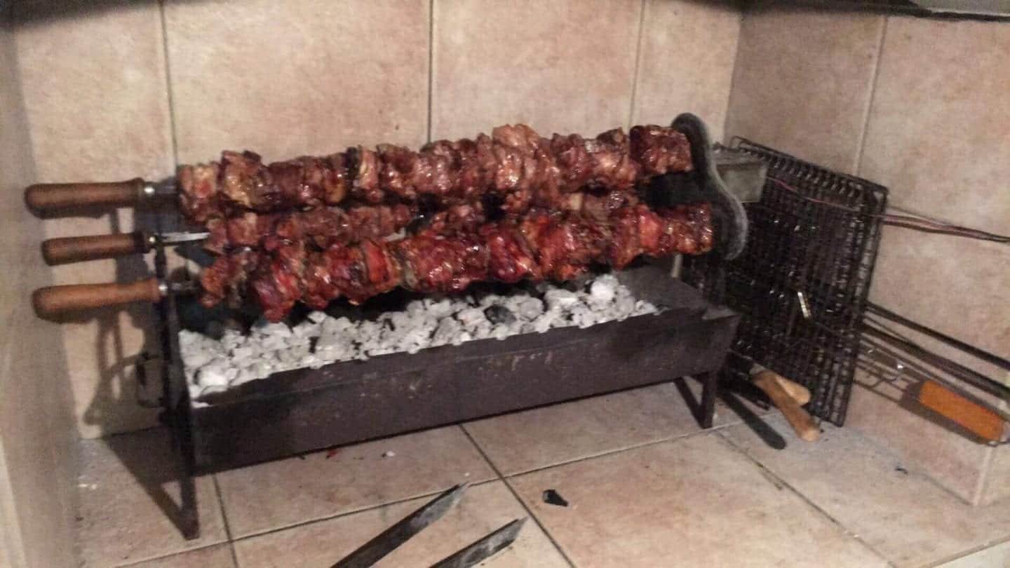 qué comer en Chipre, tres trozos de carne girando sobre un mini fuego de carbón