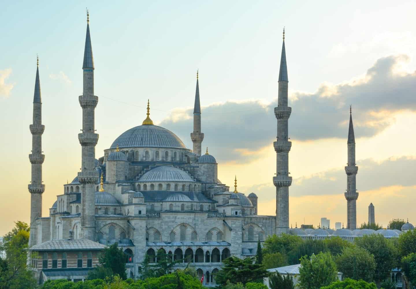 Vea los mejores lugares para visitar en Turquía, toma de la ornamentada mezquita Hagia Sophia con techos abovedados y pilares altos y puntiagudos al atardecer