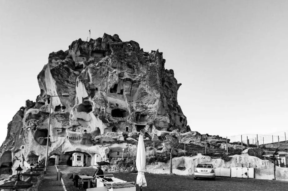 ¿Es esta la ciudad más hermosa de Turquía? Imagen en blanco y negro de una gran estructura de piedra en Uchisar con formaciones naturales inusuales.