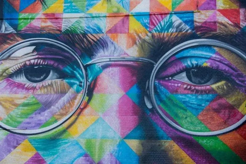 Elija su mejor ciudad favorita para visitar en invierno en Europa, cerca del colorido arte callejero de los ojos y anteojos de John Lennon pintados con un arco iris de formas triangulares