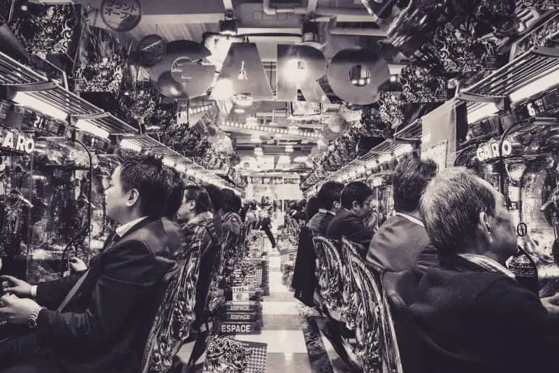 Datos desconocidos sobre Japón, imagen en blanco y negro de un largo pasillo de arcade con hombres en trajes sentados jugando juegos
