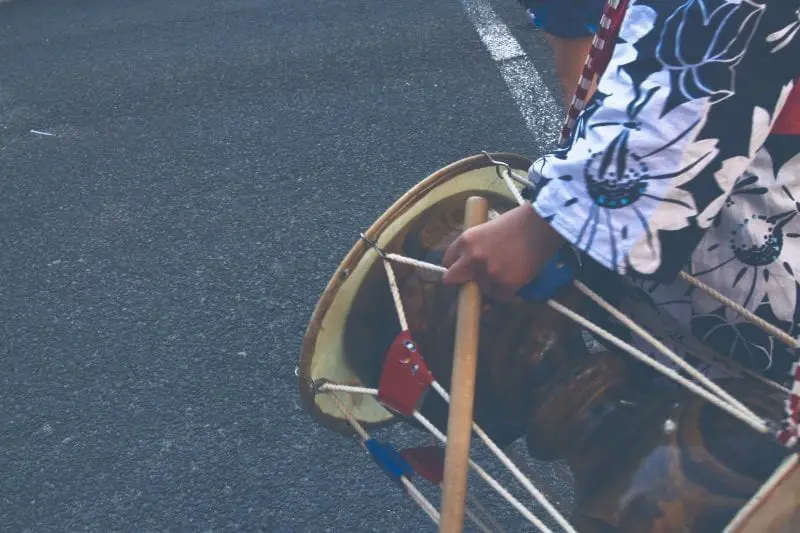 Datos interesantes sobre Japón para disfrutar, fotografía de primer plano de una persona vestida con un traje tradicional sosteniendo un tambor japonés