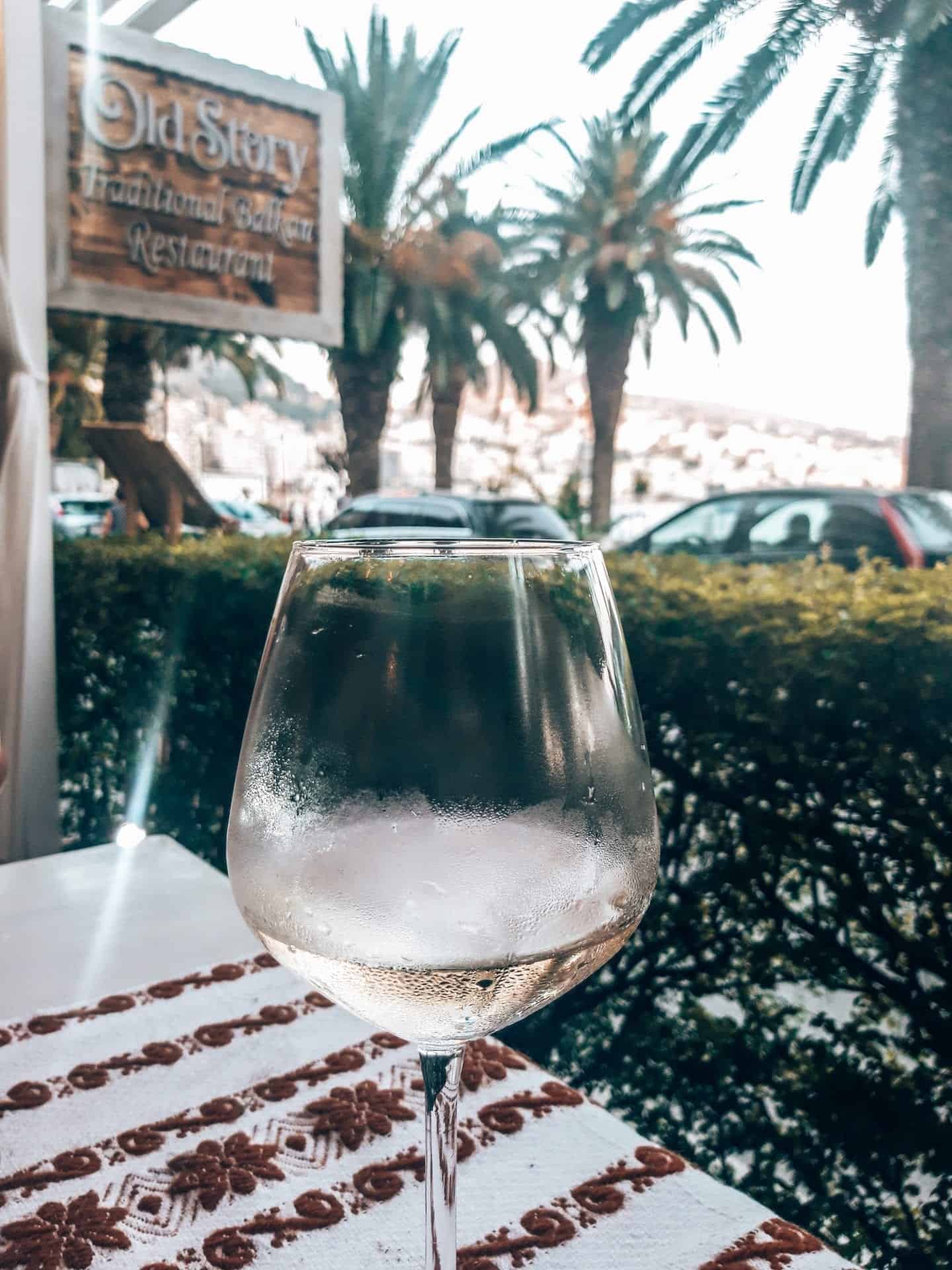Recetas de postres albaneses para disfrutar, primer plano de una copa fría de vino blanco albanés