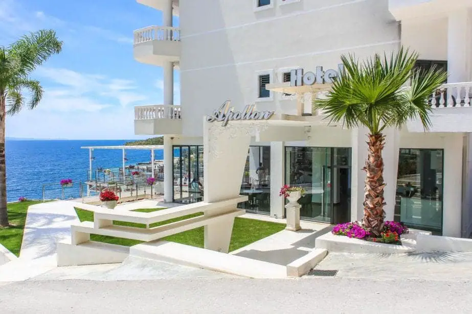 Echa un vistazo a los mejores hoteles en Sarande, frente al Hotel Apollon con un jardín bien cuidado con un árbol de playa y flores de colores, así como asientos al aire libre y un área de bar al costado