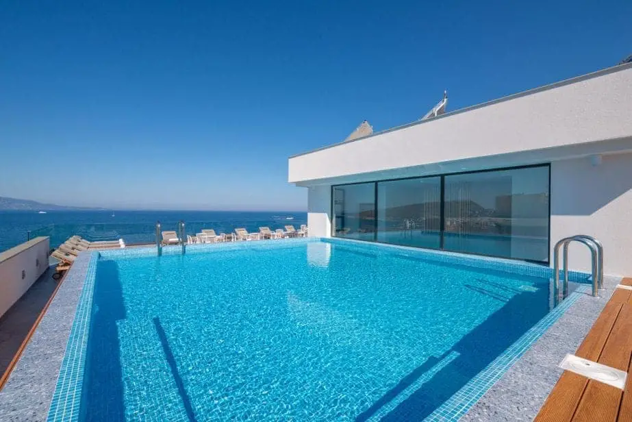 Encuentre el mejor alojamiento en Albania, gran piscina al aire libre con azulejos azules y agua clara junto a la vista al mar