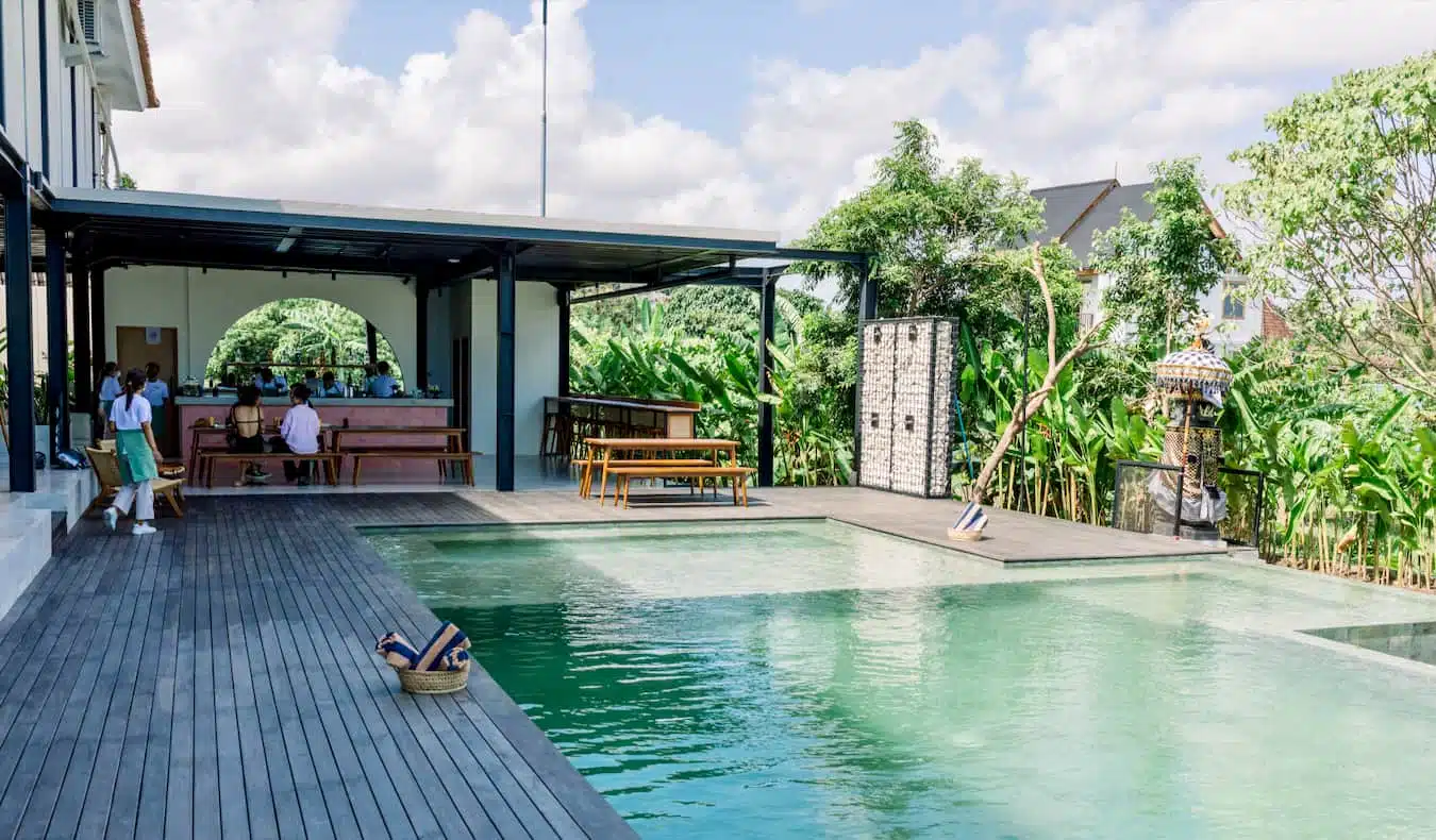 Gente pasando el rato cerca de la piscina en el albergue Tribal Bali