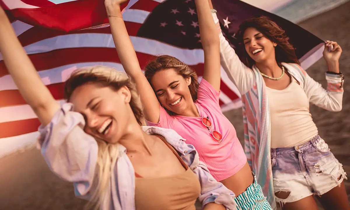 chicas sosteniendo una bandera de estados unidos