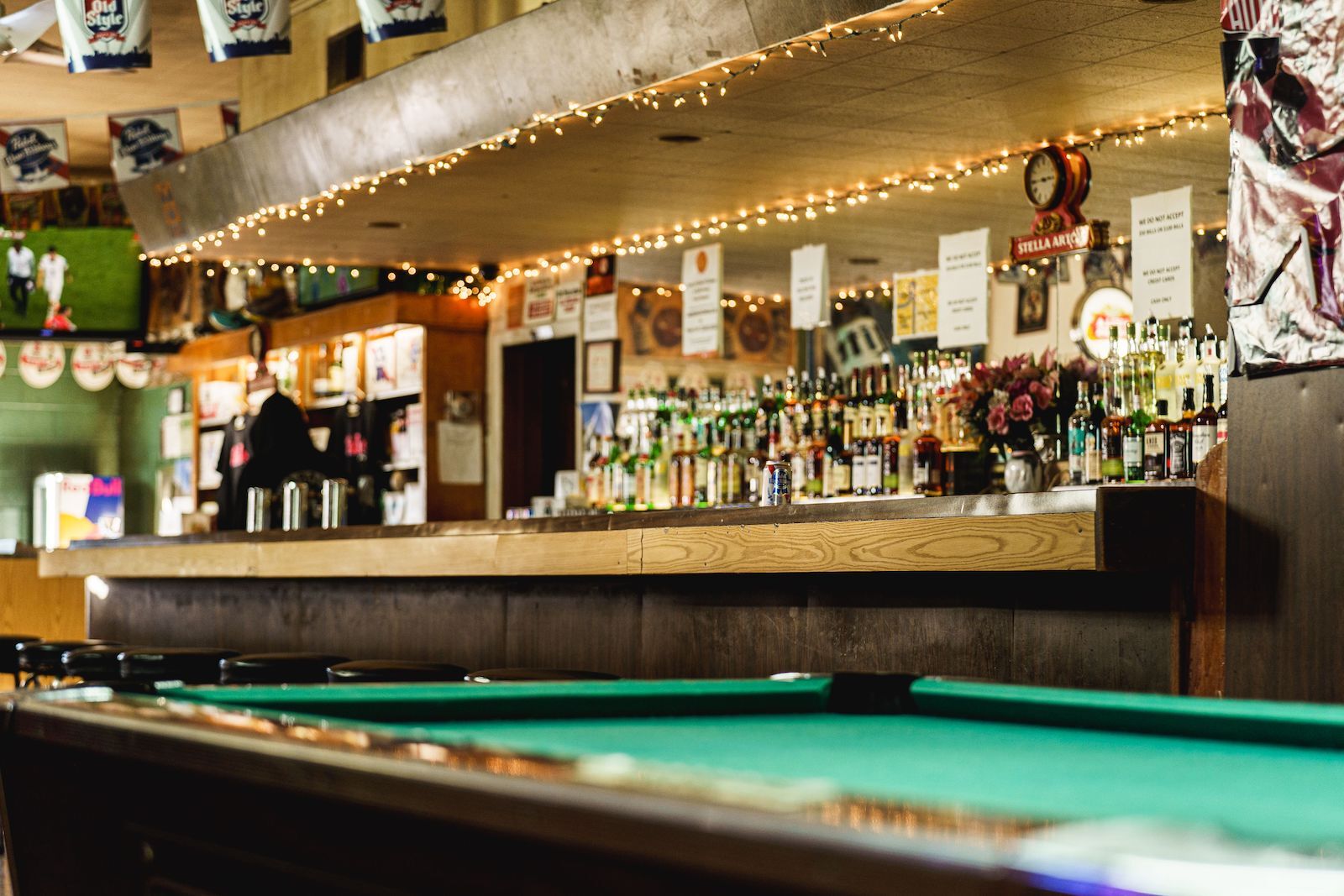 dive bar Chicago llamado Stellas con mesa de billar y lata de Pabst blue ribbon en la barra