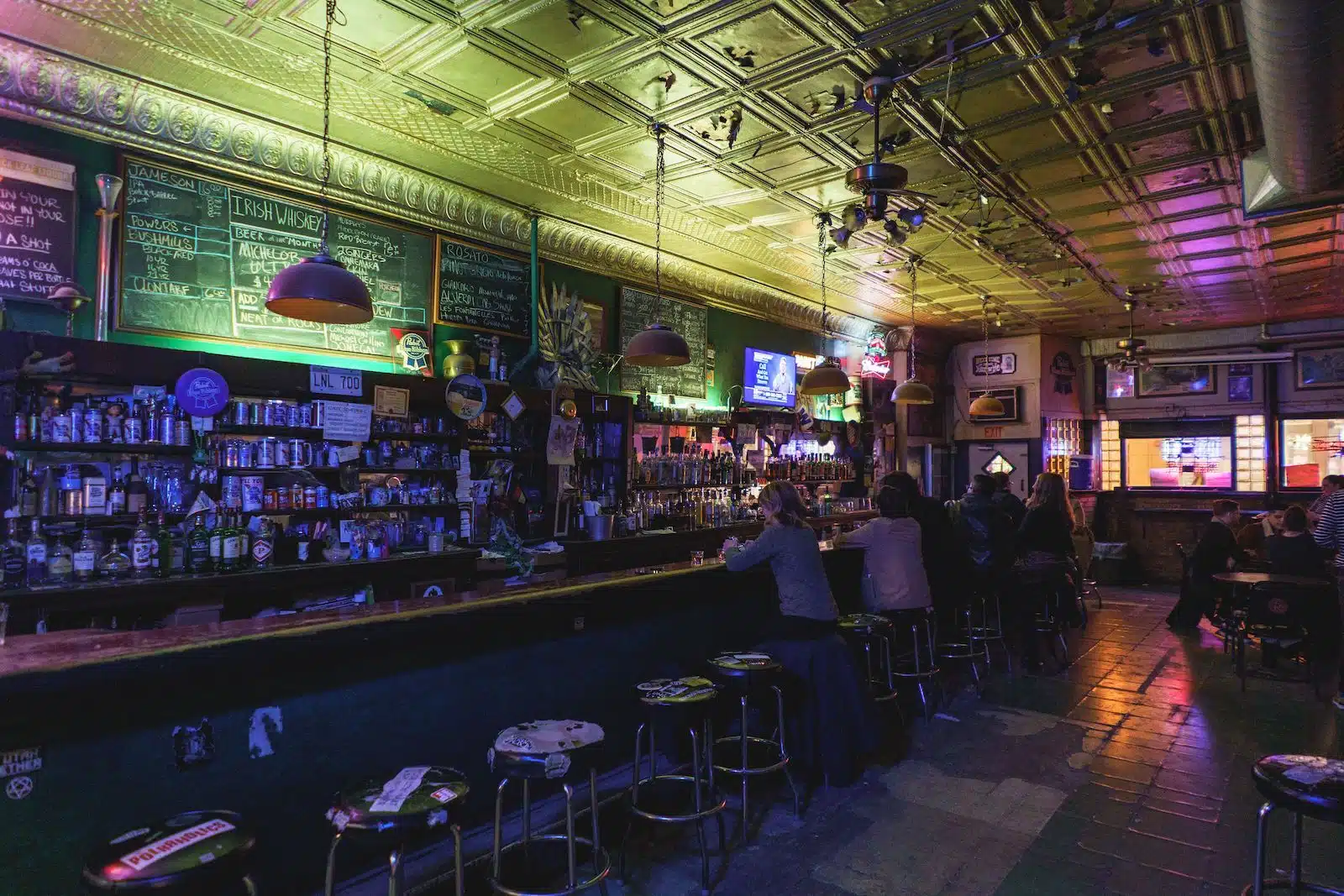 Interior del antro L&L de Chicago con clientes en la barra y luces verdes 