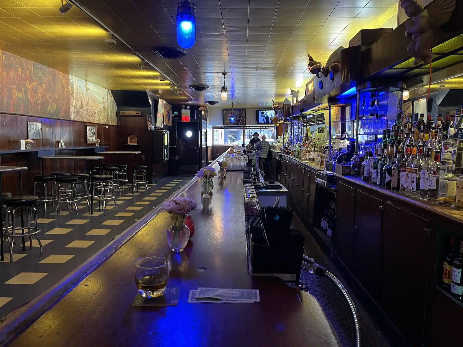 Simons dive bar Chicago con suelos de baldosas blancas y negras, barra y taburetes de bar 