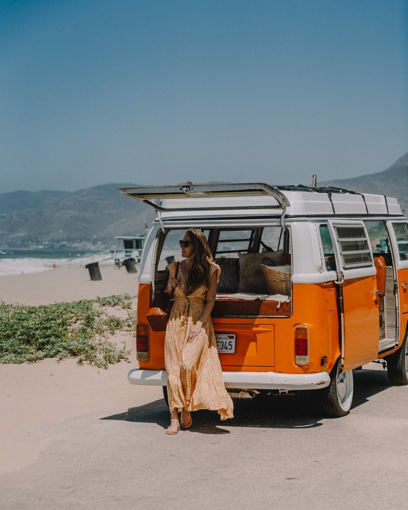 Michelle Halpern en Malibú, California, con un autobús VW naranja en la playa