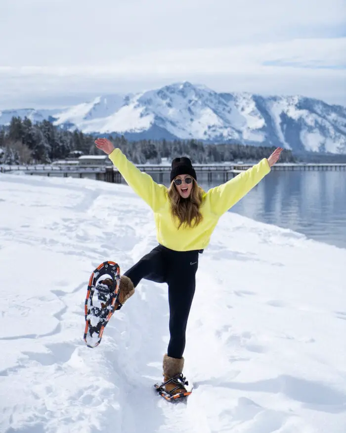 Michelle Halpern con un polar neón y raquetas de nieve frente al lago Tahoe