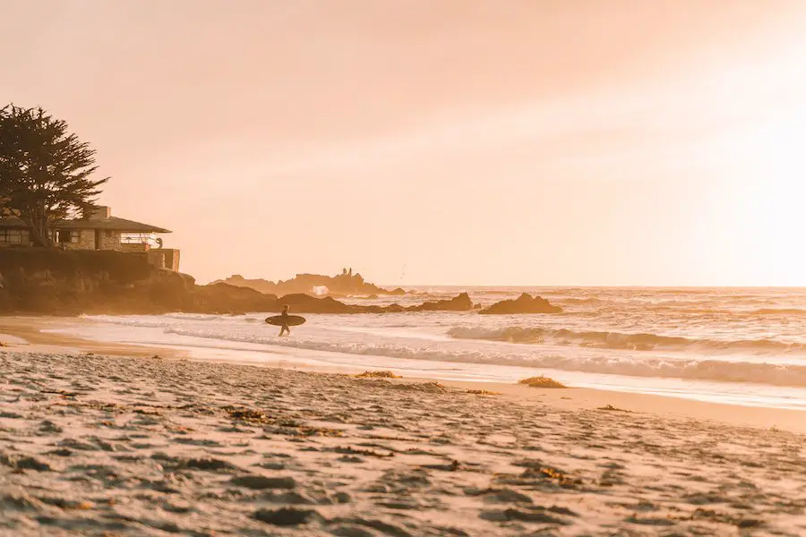 Un surfista se dirigió hacia las olas al atardecer en Carmel, California