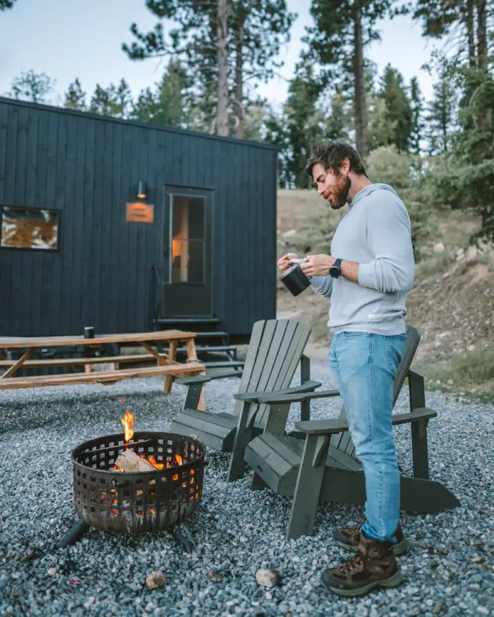 Louis junto al fuego frente a la cabaña Getaway