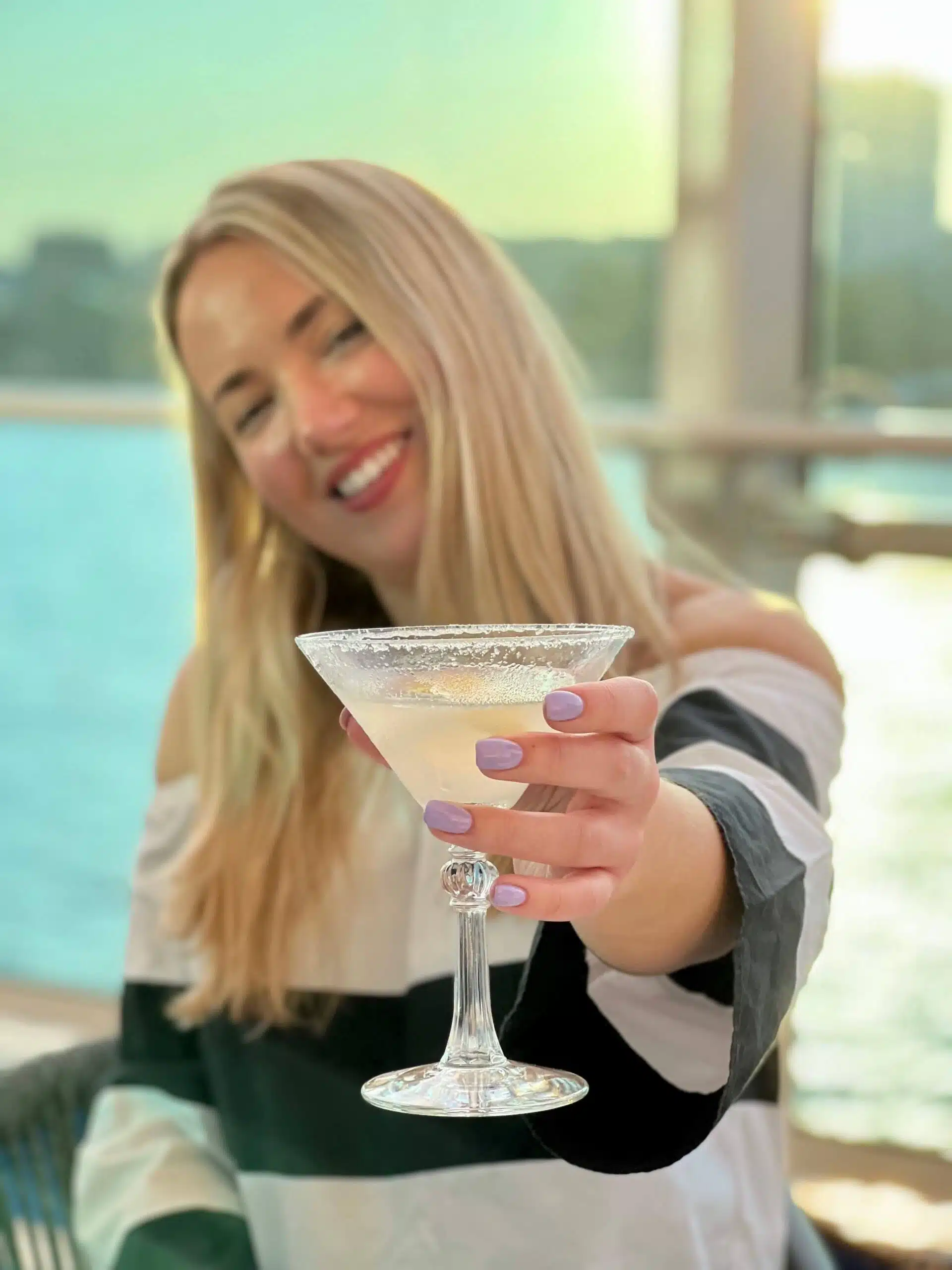 Mujer sosteniendo a Margarita con uñas moradas
