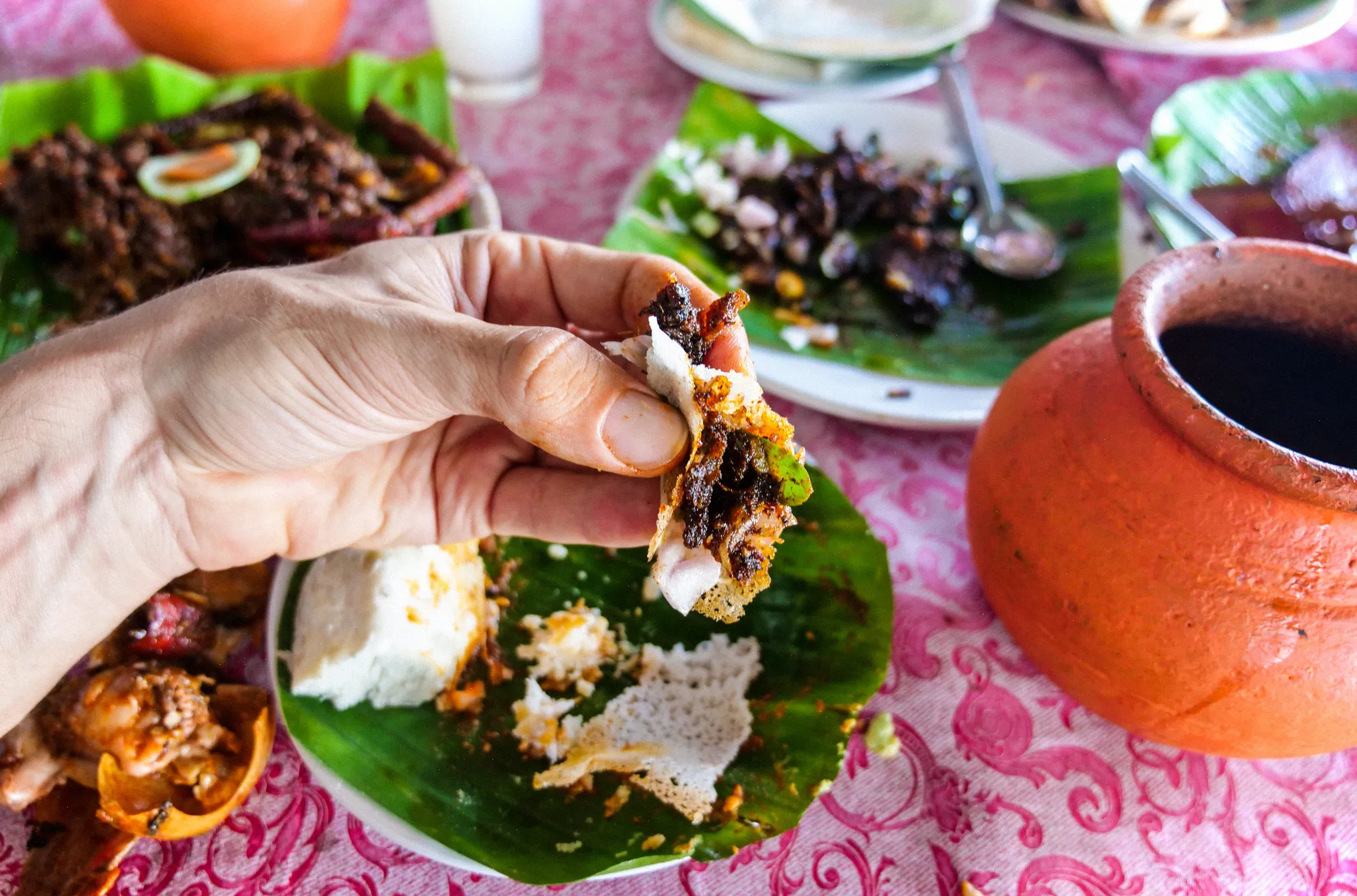 Comer con las manos mientras se cena en Kerala Toddy Shop es la forma tradicional con Appam y Cassava.